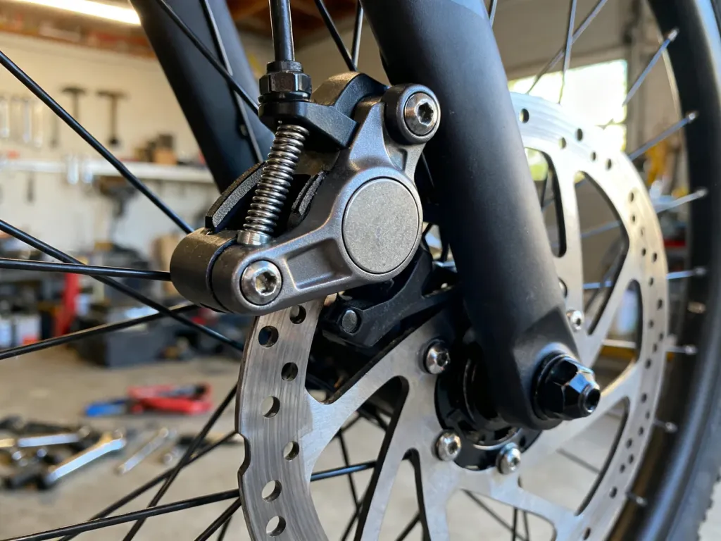 Zbliżenie na mechanizm regulacji szczęk hamulcowych roweru w profesjonalnym warsztacie.